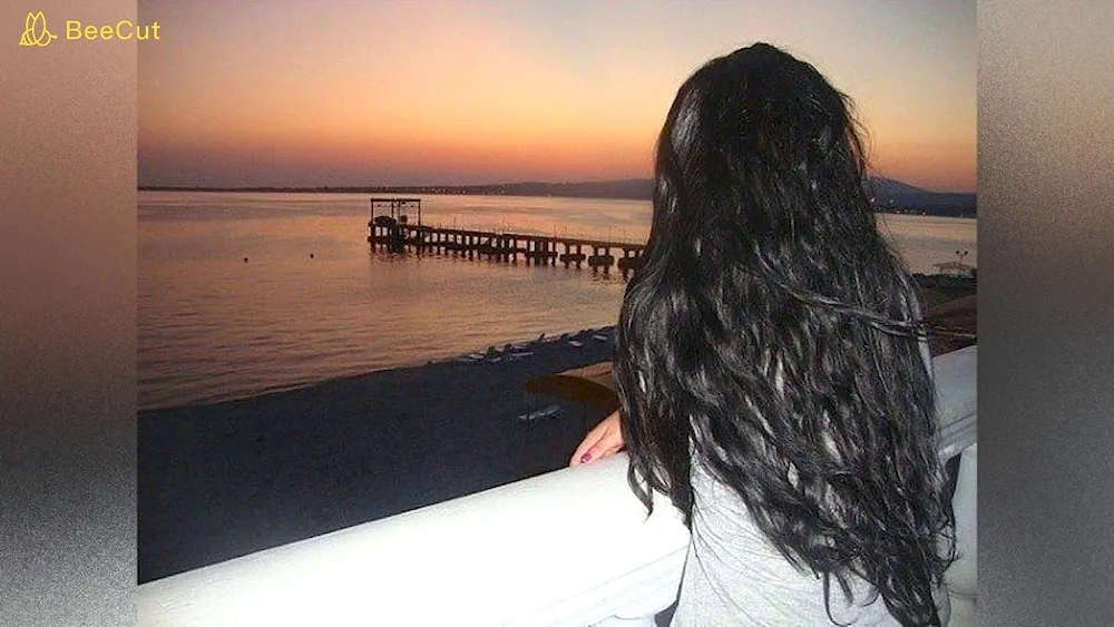 Brunette with long hair with black hair at the sea