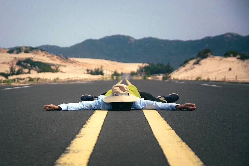 Man in the desert lying on the road