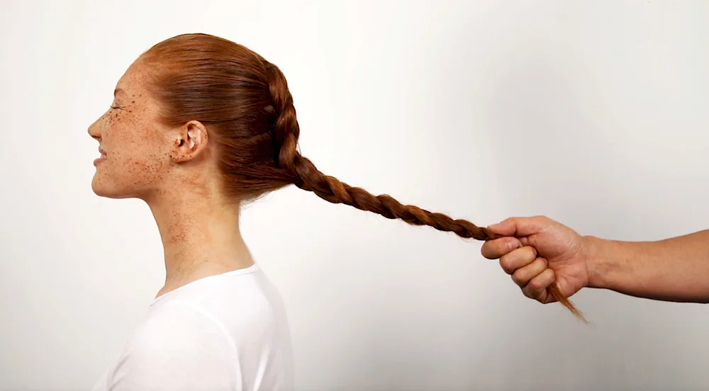 Guy braiding girl's hair