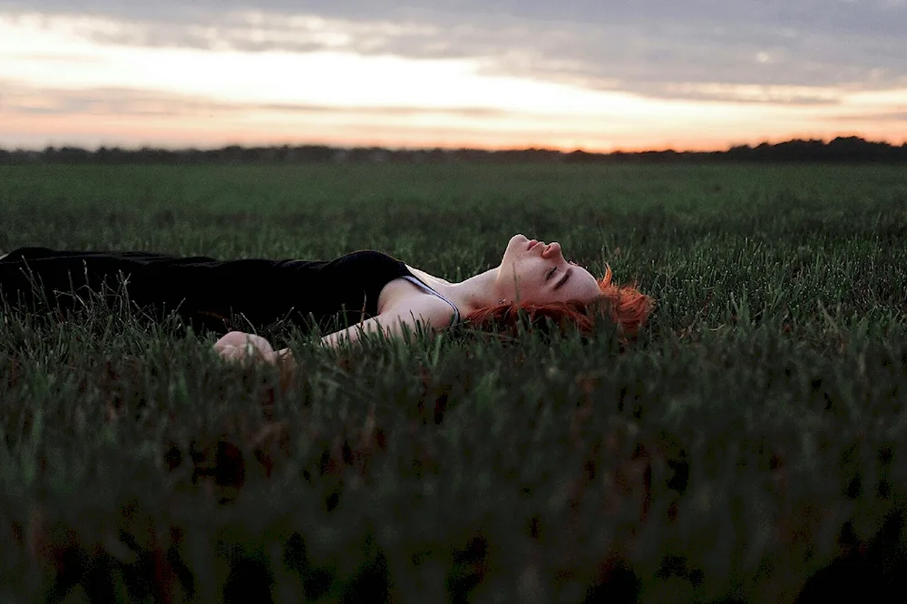 The girl is lying in a field