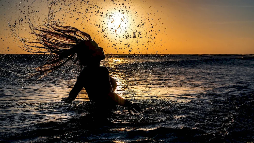 Girl at sunset by the sea