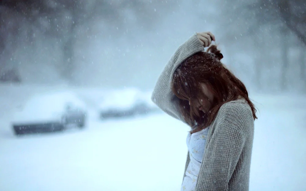 Girl in winter with back in snow