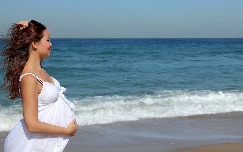 Pregnant girl at the beach sea