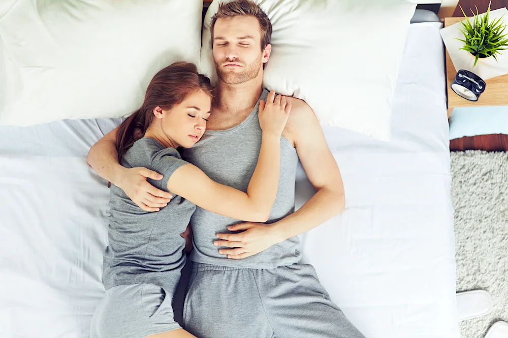 Couple lying in an embrace on a sofa