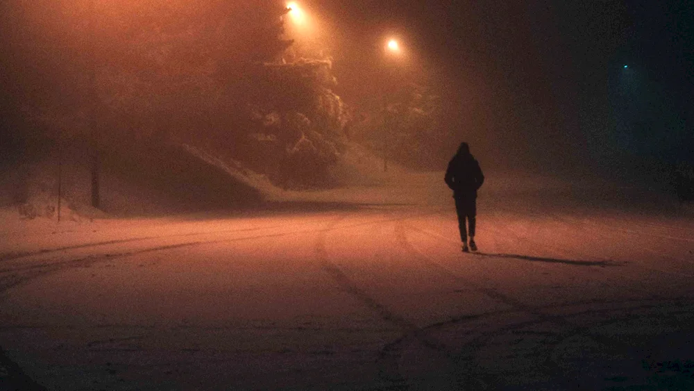 A man walking in the dark under the starry sky
