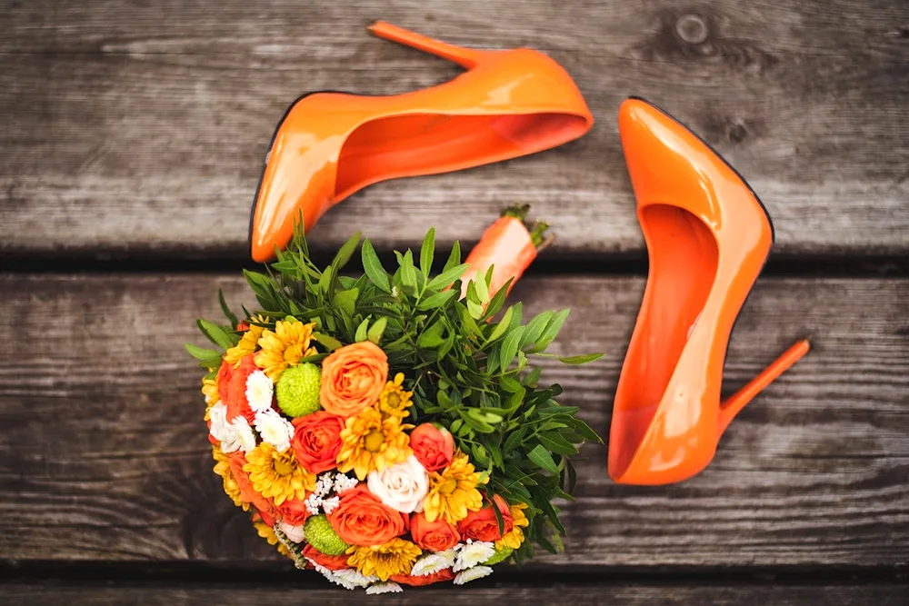 Red heel shoes under an orange dress