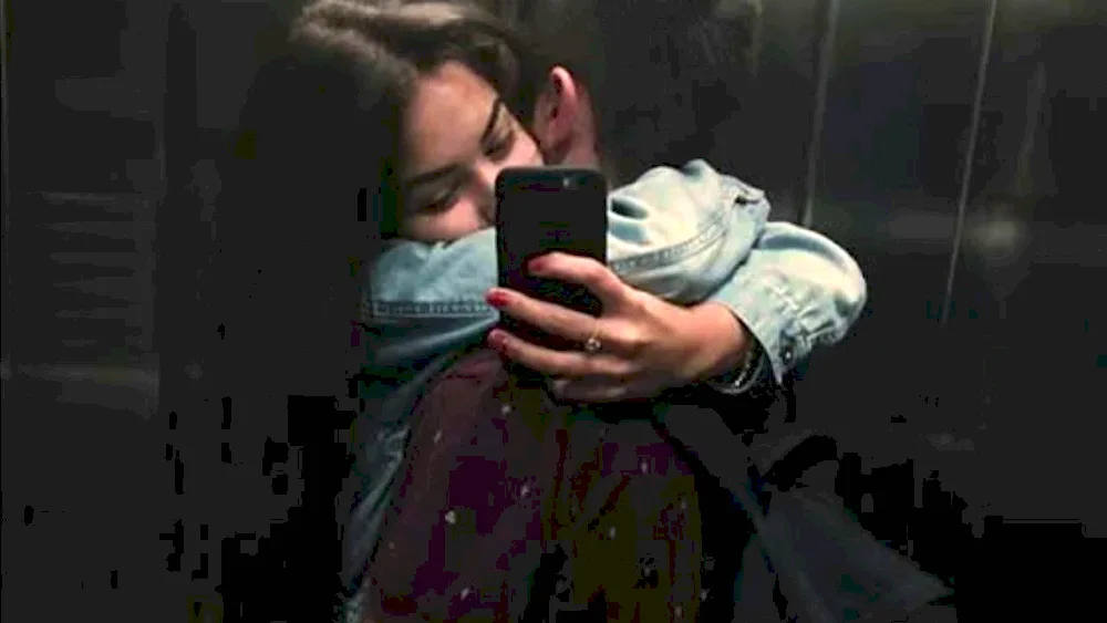 Guy hugs girl in mirror