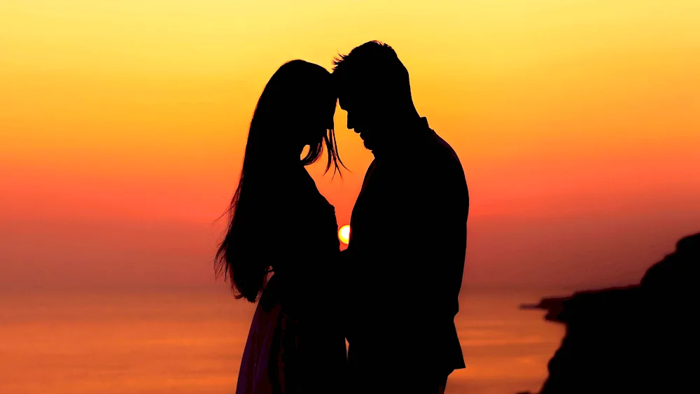 A guy and a girl against the sunset background