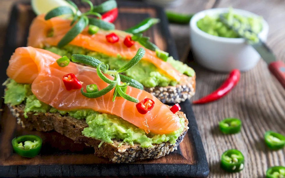 Salmon sandwich with avocado. avocado. Cold appetisers. Sandwiches for the festive table. Decorate sandwiches