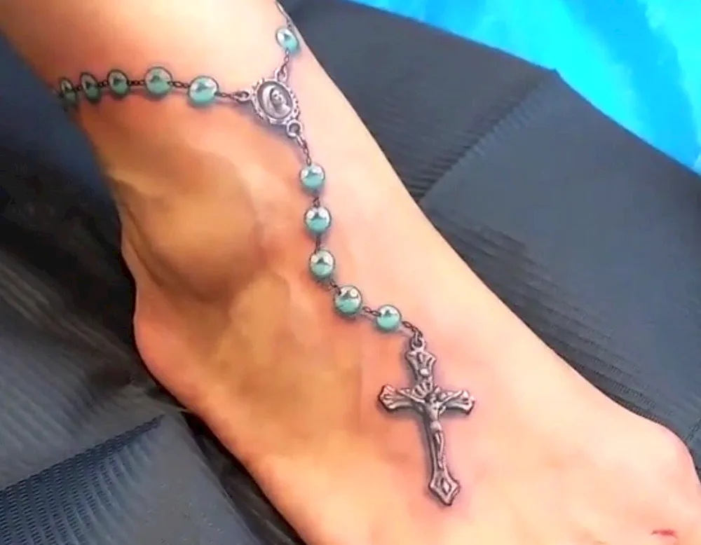 Tattoo rosary with cross on leg