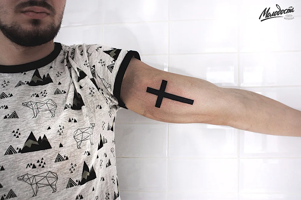 Cross tattoo on the arm