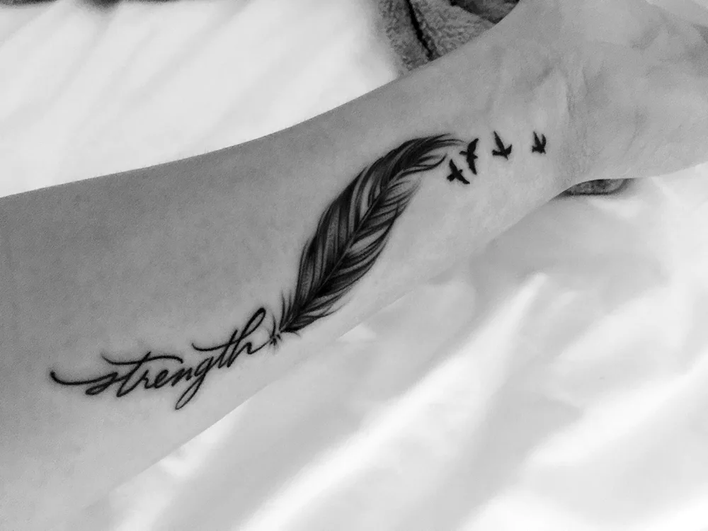 feather tattoo on the shoulder blade