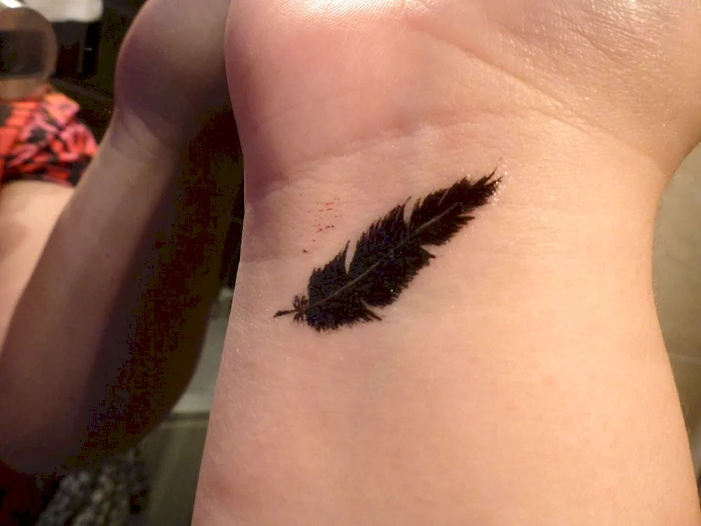 Wrist feather tattoos