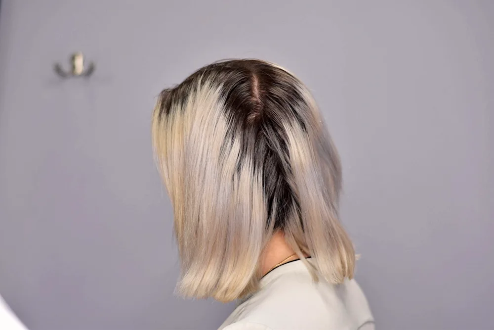 Total blond colouring photo from back on black background