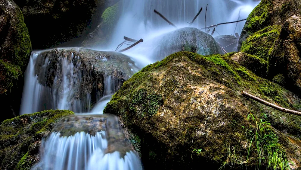 Waterfalls cascade with stones and mountains
