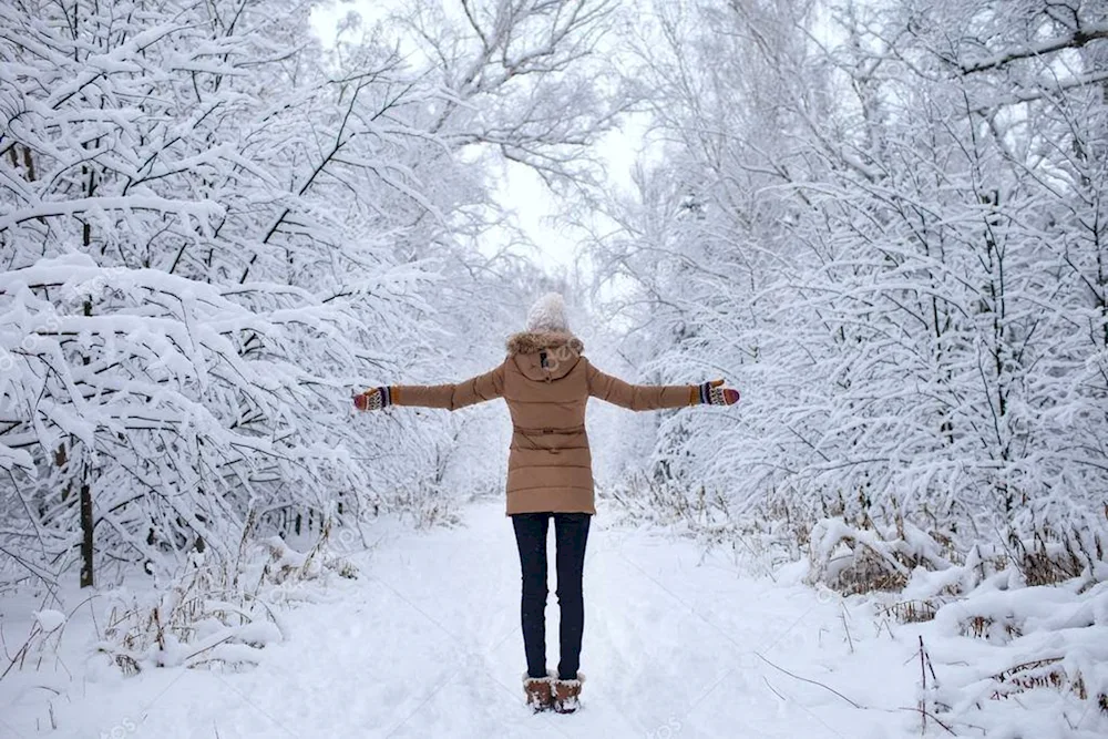 Woman in winter forest from back
